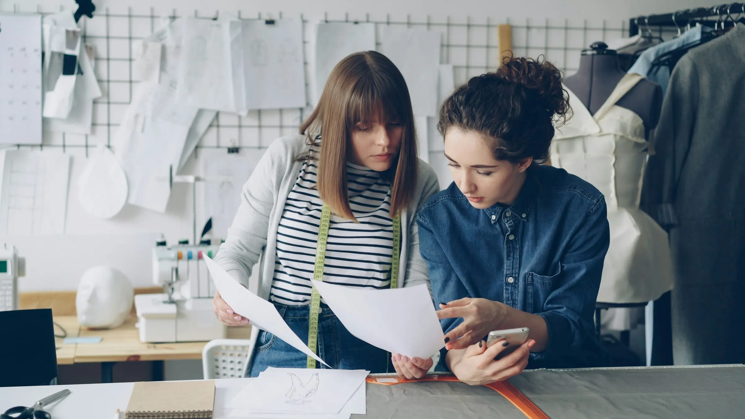 Two designers reviewing patterns in a tailoring studio